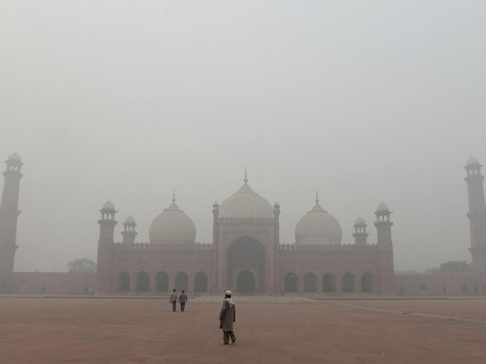 People visit Badshahi Mosque amid heavy smog in Lahore, Pakistan, on November 9. The government has ordered public spaces to close in smog-hit cities.