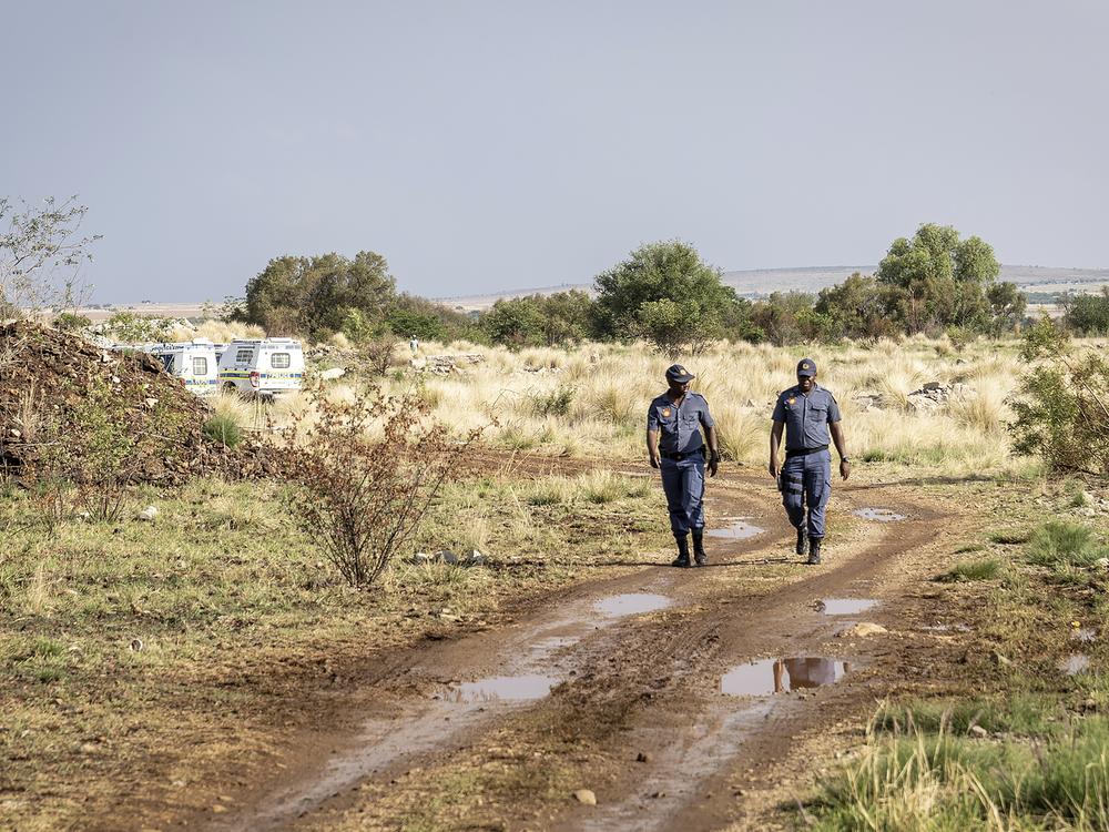 Police patrol near a closed mine where illegal miners are inside in Stilfontein, South Africa on Wednesday.