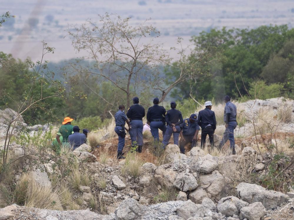 Rescue workers, left, remove a body from a reformed mineshaft where illegal miners are inside in Stilfontein, South Africa on Thursday.