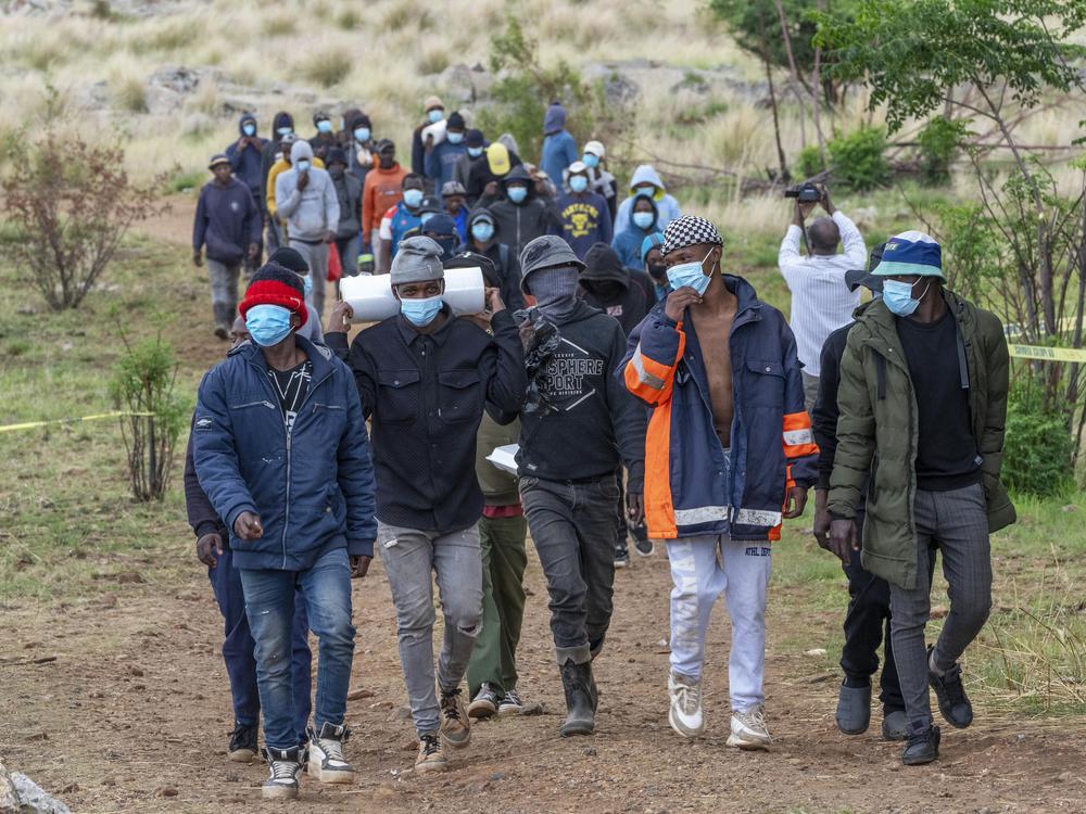 Volunteer rescue workers and community members leave the area near a closed mine where illegal miners are inside in Stilfontein, South Africa on Thursday.