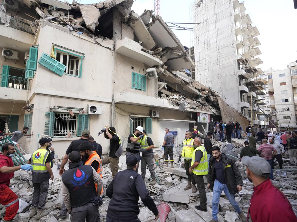 Residents and rescuers gather near a damaged building at the site of an Israeli airstrike in central Beirut's Ras el-Nabaa neighborhood, Lebanon, Sunday, Nov. 17, 2024.