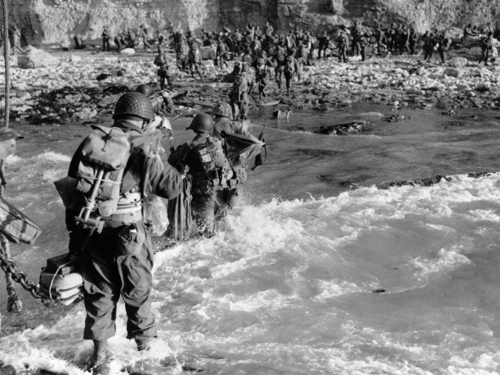 U.S. reinforcements wade through the surf as they land at Normandy in the days following the Allies' June 1944 D-Day invasion of occupied France.
