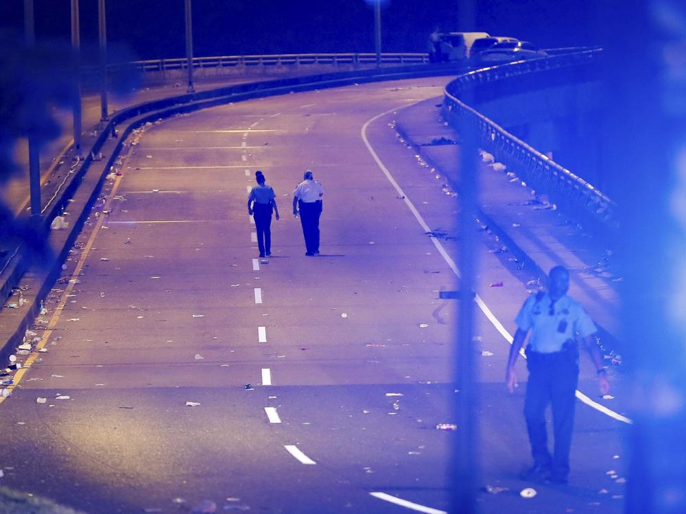 New Orleans police walk up the Almonaster Avenue bridge after a deadly shooting in New Orleans, Sunday, Nov. 17, 2024.