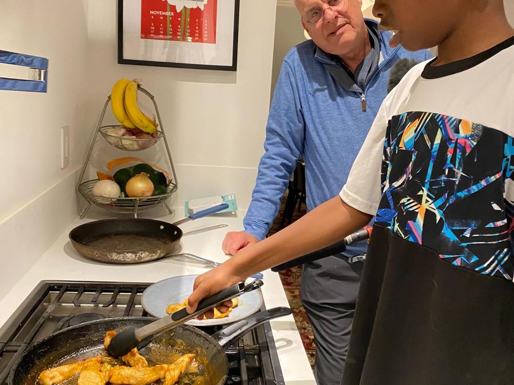Ayesha Rascoe's son, Reggie (11), sautés chicken with help from Mark Bittman.