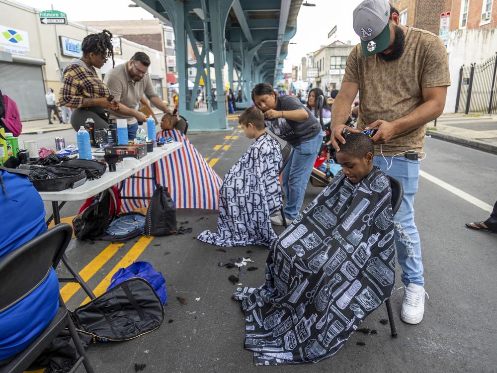 Trainees from the Lehigh Valley Barber and Beauty Academy provide free haircuts as part of a local back-to-school event near Philadelphia's Kensington neighborhood on Aug. 12, 2024.
