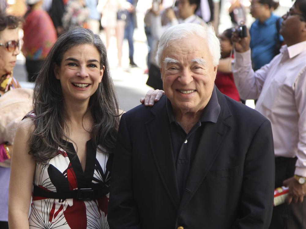 Arthur Frommer, 83, and his daughter, Pauline Frommer, 46, are shown posing among tourists in the Wall Street area in New York, May 20, 2012.