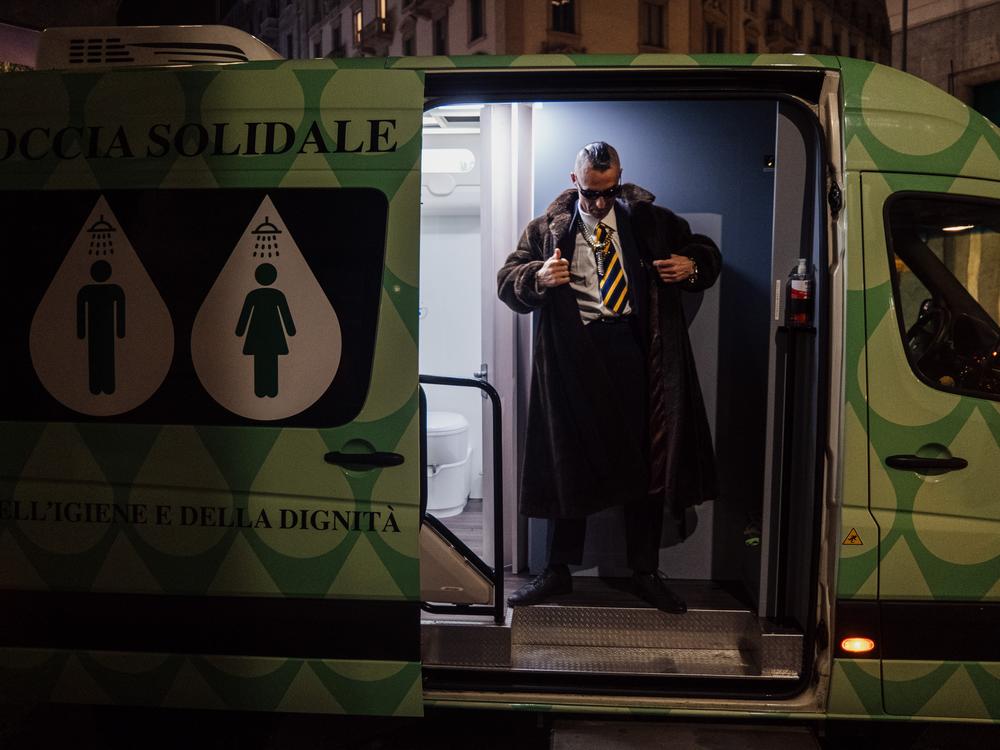 This man is stepping out from a van that offers showers and bathroom facilities to the homeless. Known for his elegant garb, he is one of the 2,000 or so people who live on the streets in Milan, Italy — the number comes from a city survey. An Italian charity called Alatha sponsors the 