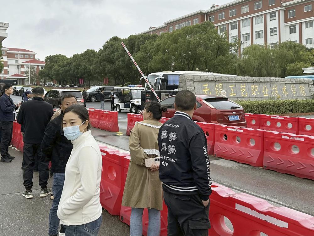 Guardians gather in front of the Wuxi Vocational Institute of Arts and Technology in Yixing, eastern Chinese city of Wuxi on Nov. 17, 2024, a day after a stabbing attack took place.
