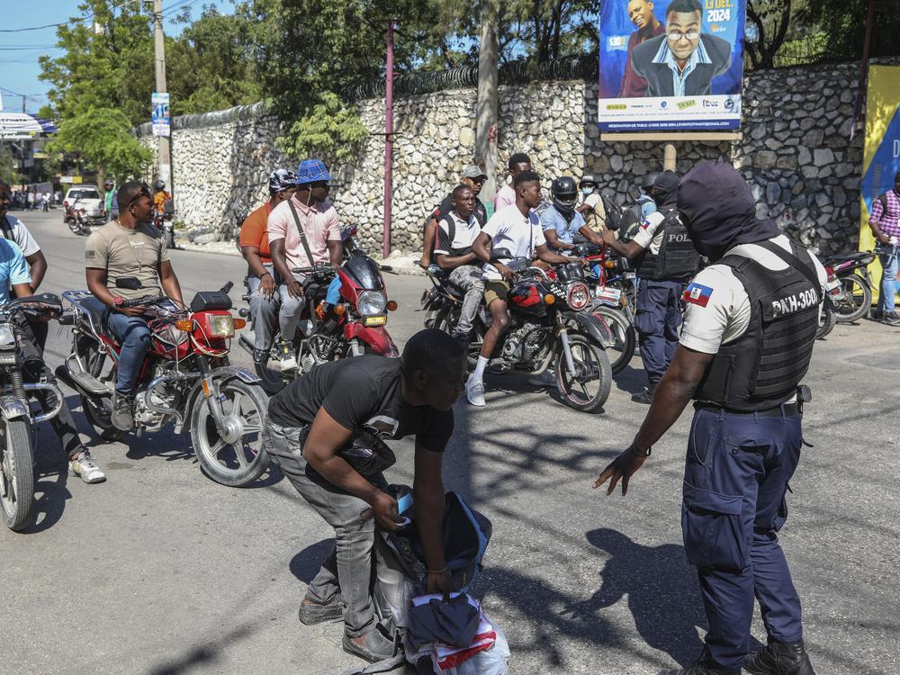 Police officers man a checkpoint checking for weapons, in the Petionville area of Port-au-Prince on Tuesday.