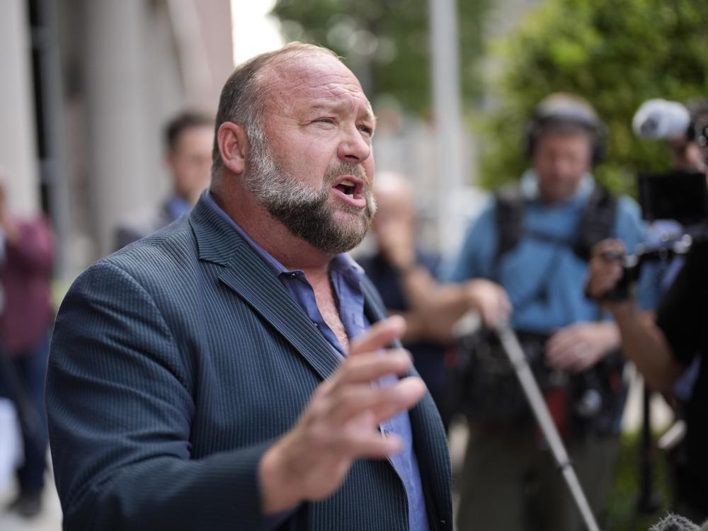 Right-wing conspiracy theorist Alex Jones speaks to the media after arriving at the federal courthouse in Houston for a bankruptcy hearing in June.