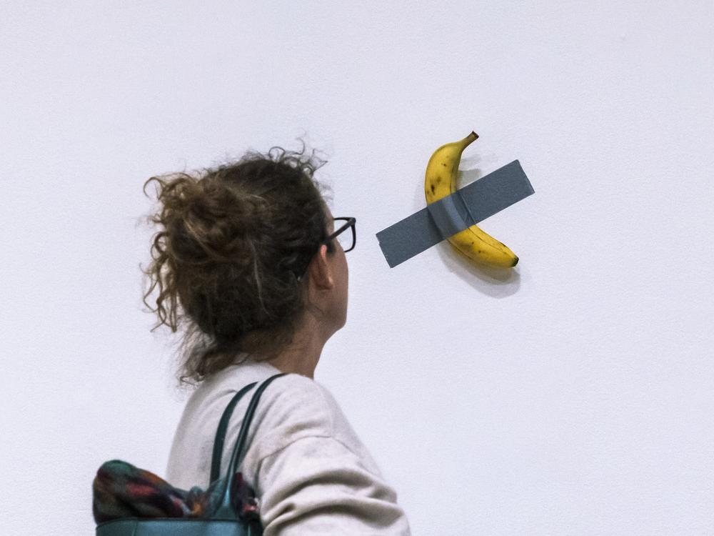 A woman looks at artist Maurizio Cattelan's piece of art <em>Comedian</em> during an auction preview at Sotheby's in New York on Nov. 11, 2024.