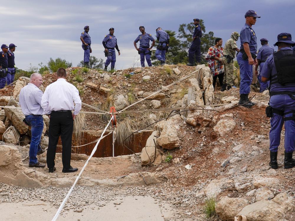 Police officers and private security personnel stand by the opening of a reformed gold mineshaft where illegal miners are trapped in Stilfontein, South Africa, Nov. 15.