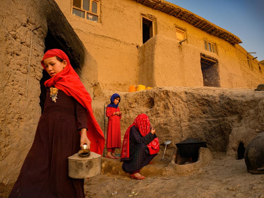 Family members gather by a stove in Afghanistan, which has been hit by droughts over the past three years. The country is ranked one of the most vulnerable and ill-prepared nations in coping with climate change. Global support for projects to address climate-related issues has been largely on hold since the Taliban took power.