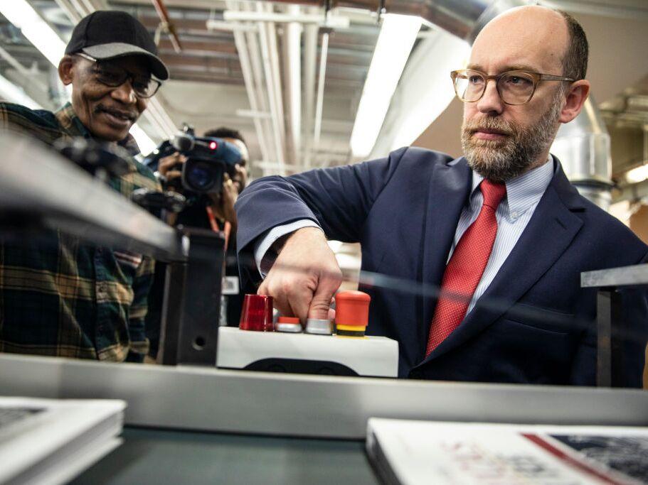 Then-acting Director of the Office of Management and Budget Russ Vought is seen starting the machine that will print copies of then-President Trump's proposed budget in February 2020. Trump has nominated him for as budget director again for his second term.