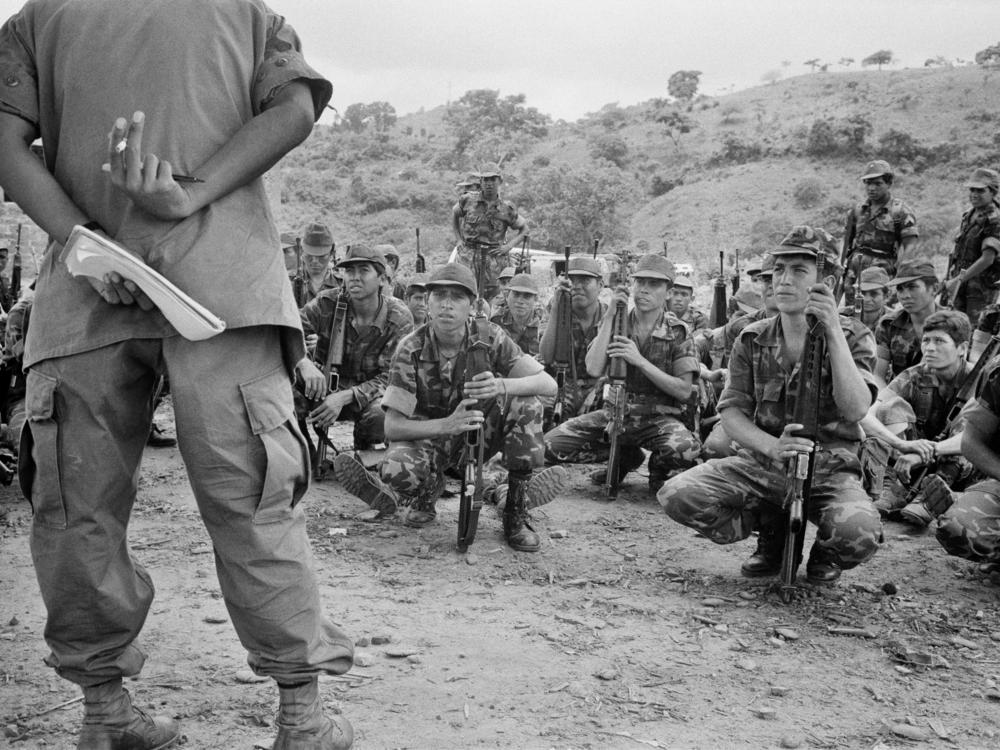 A U.S. Army advisor (left) leads Salvadoran army soldiers during an open air class in San Juan Opico, El Salvador, on June 20, 1983.
