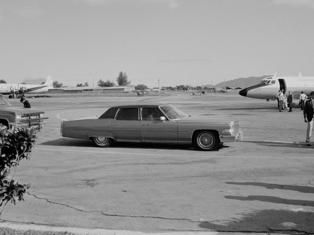 An armored Cadillac belonging to the U.S. Embassy pulls up to an arriving U.S. government jet plane in Ilopango, El Salvador, in November 1982.