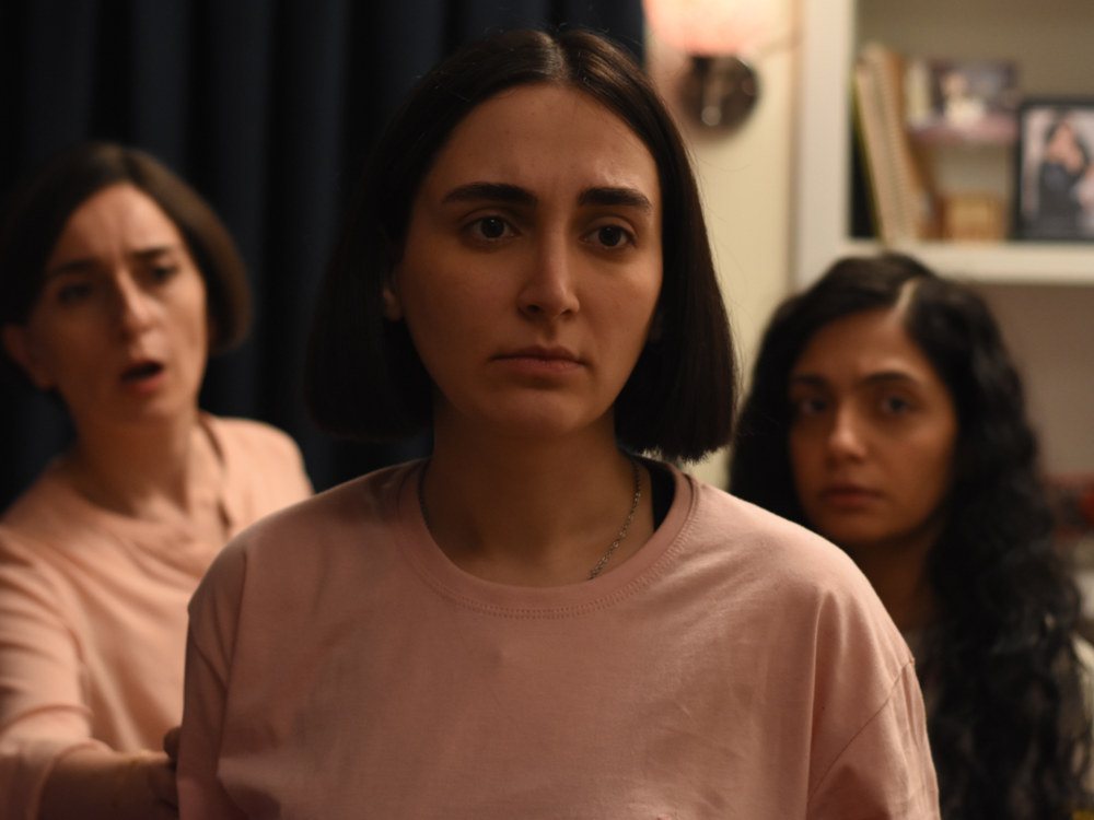The two daughters of an investigator at Iran's Islamic Revolutionary Court — Rezvan (center, Mahsa Rostami) and Sana (right, Setareh Maleki) — question their father's role in a government crackdown on protests, while their mother, Najmeh, (left, Soheila Golestani) tries to maintain the balance in the family in Mohammad Rasoulof's <em>The Seed of The Sacred Fig</em>.