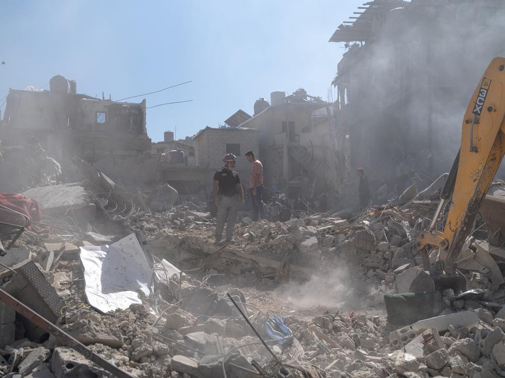 A firefighter stands at the site of an Israeli airstrike near Rafik Hariri University Hospital. In all, 18 people were killed in that attack, including children.