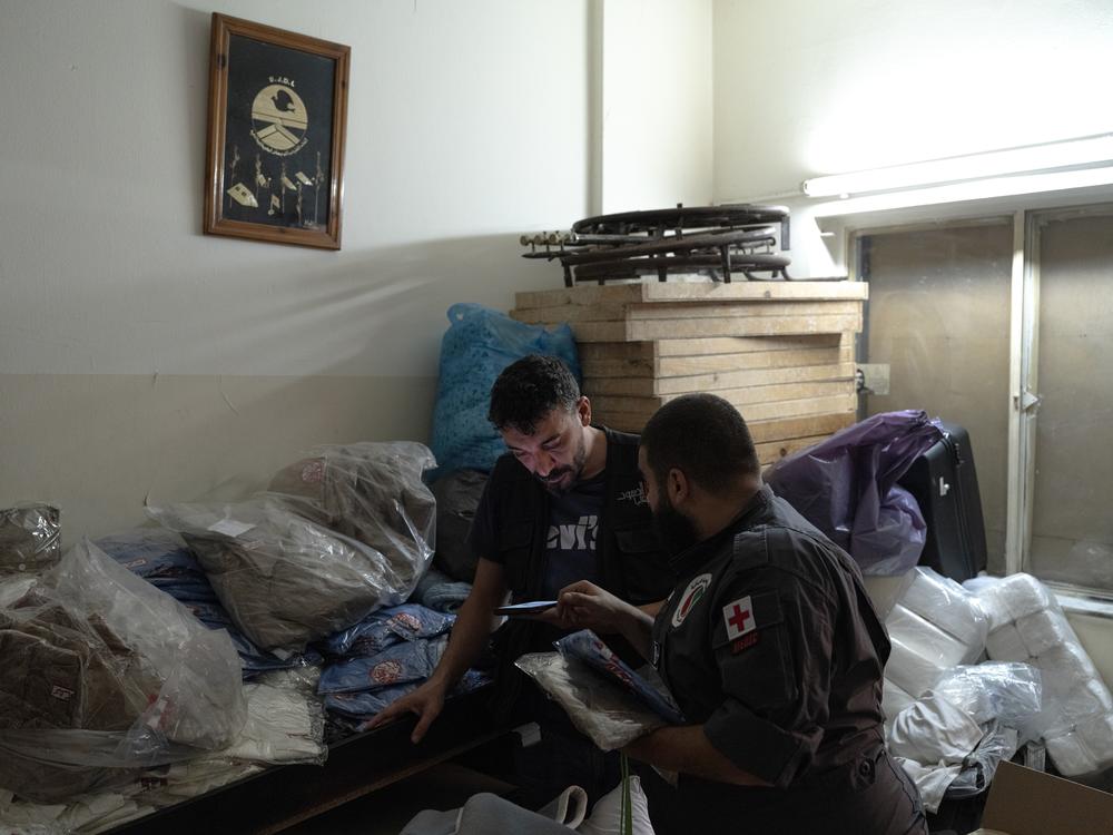 Jad Deeb, a volunteer of the Lebanese Popular Relief Association, prepares school clothes for displaced Lebanese children with one of his colleagues in their office in Beirut, Lebanon.