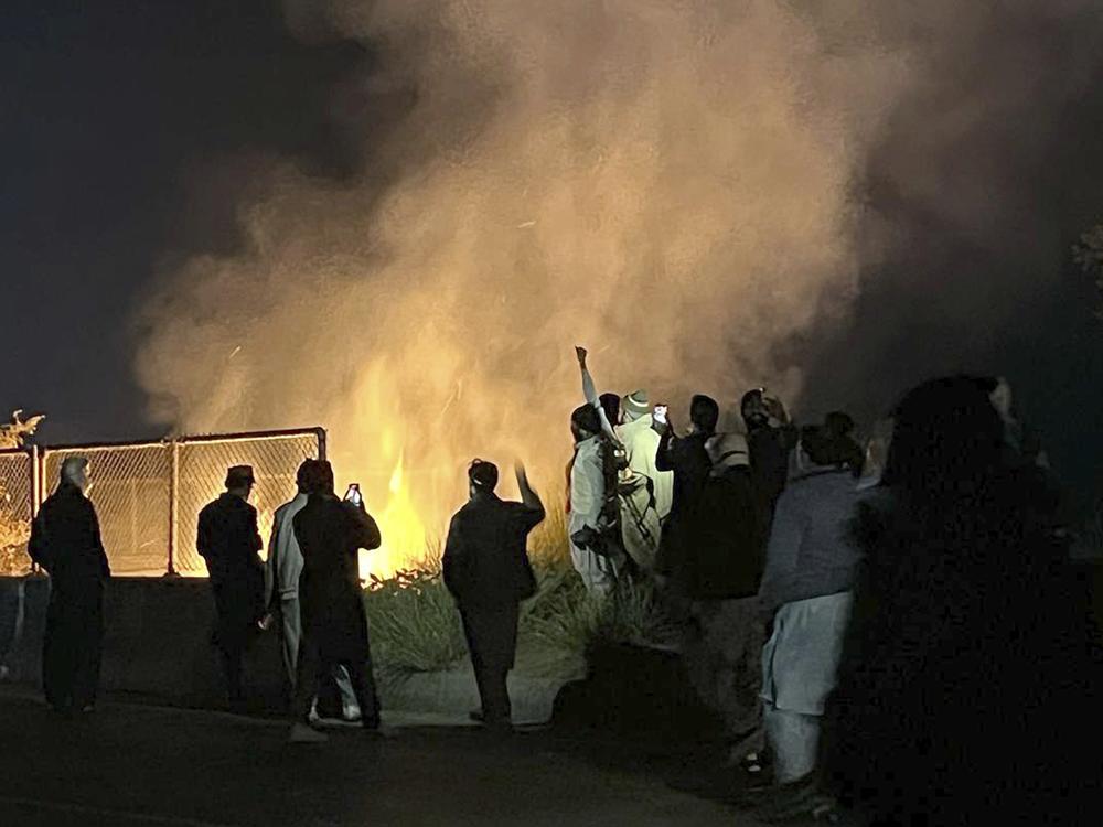 Supporters of imprisoned former premier Imran Khan's Pakistan Tehreek-e-Insaf party, burn bushes to reduce the impact of tear gas shells fired by police officers to disperse them during a rally demanding Khan's release, at a motorway in Ghazi in Attock district, Pakistan on Sunday.