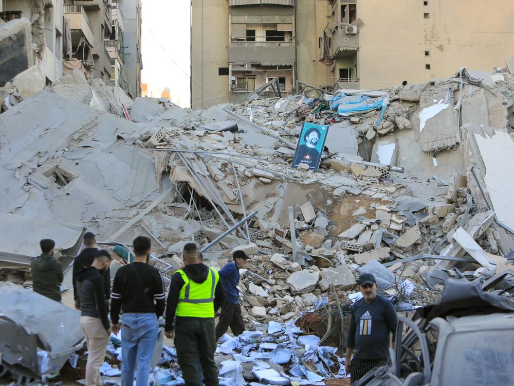 People inspect the damage at the site of an overnight Israeli airstrike that targeted a branch of the Al-Qard Al-Hassan finance group in Beirut's southern suburbs on Monday.