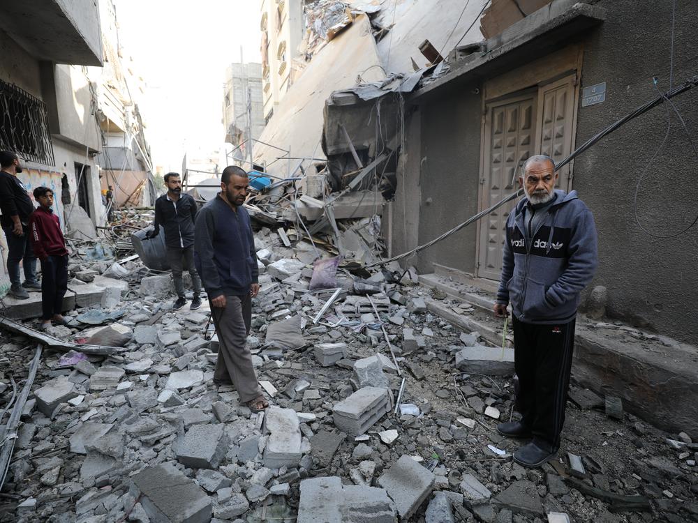 Palestinians inspect damage following an Israeli airstrike that hit a home in the north of Gaza City on Thursday.