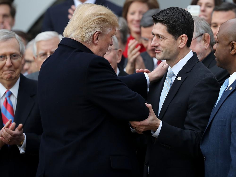 Trump congratulates then-House Speaker Paul Ryan, R-Wis., during an event to celebrate Congress passing the Tax Cuts and Jobs Act with Sen. Mitch McConnell in 2017.
