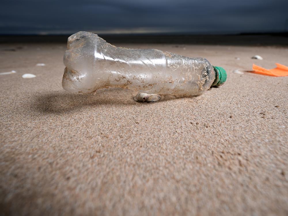 A plastic bottle and the remains of a child's spade on the beach in Prestatyn, U.K..