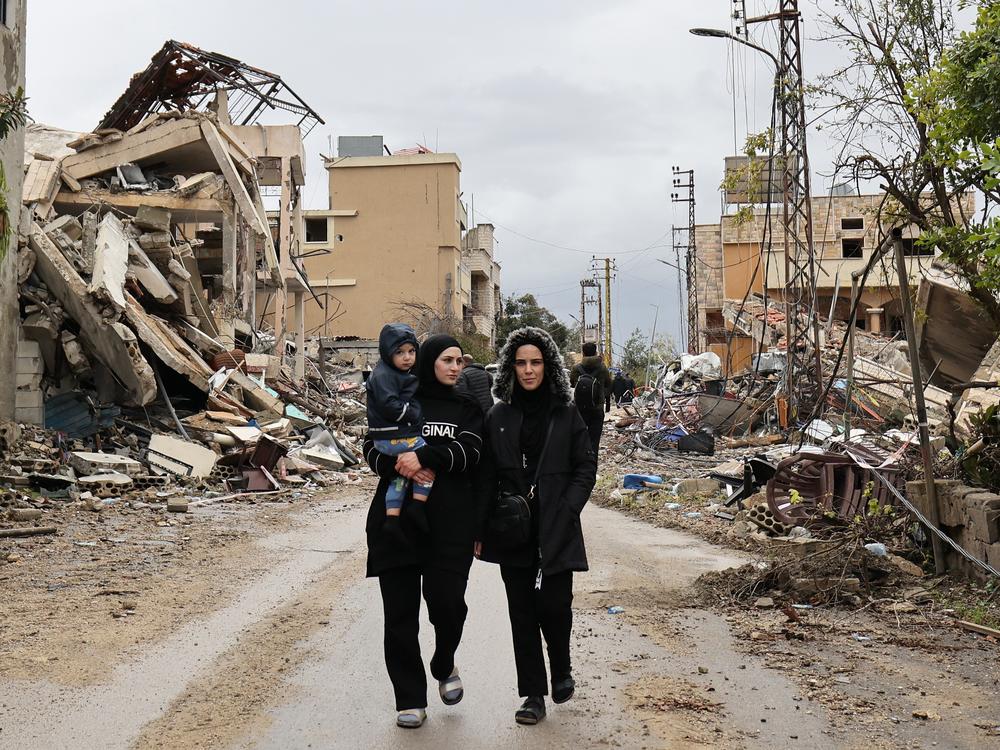 Residents walk in the southern Lebanese village of Zibqin on Wednesday, as people who had fled the war between Israel and Hezbollah returned to check on their homes after a ceasefire took effect.