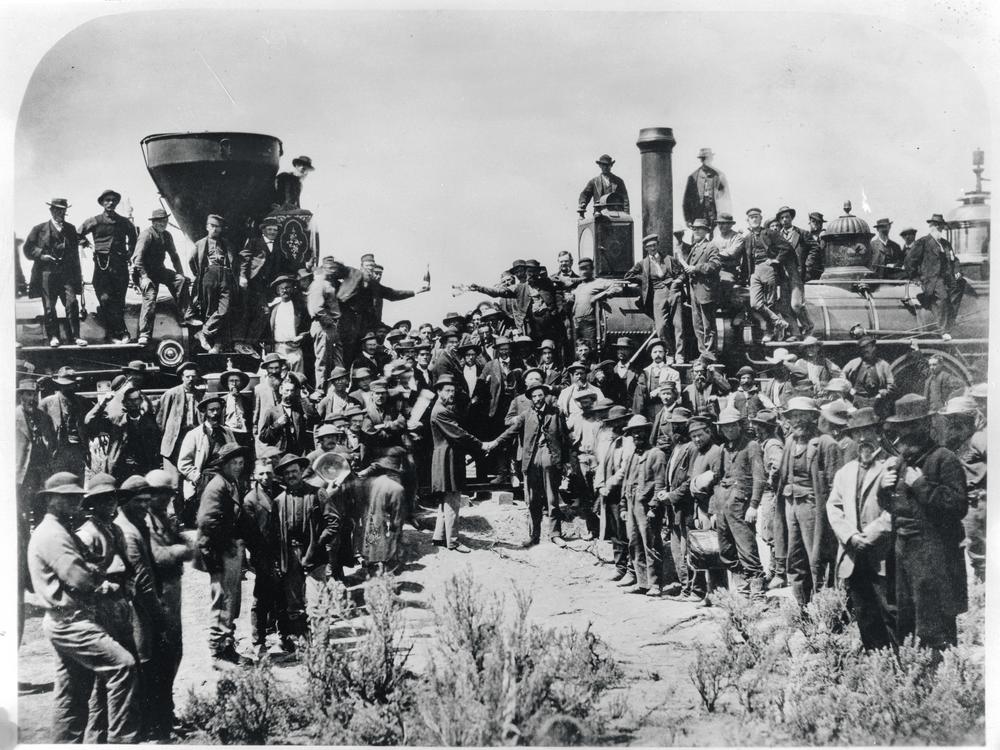 Railroad workers celebrate at the driving of the Golden Spike Ceremony in Utah on May 10, 1869 signifying completion of the first transcontinental railroad route created by joining the Central Pacific and Union Pacific Railroads.