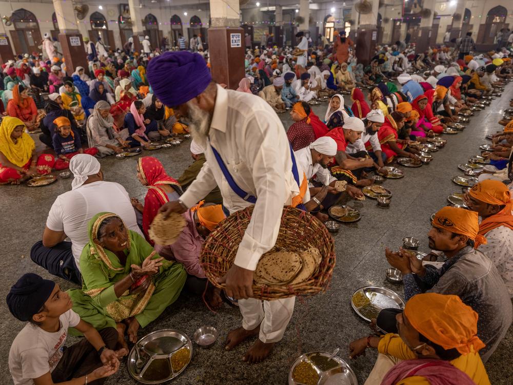 A free hot meal is served at the Sri Harmandir Sahib, better known as the Golden Temple, in Amritsar in Punjab State, India. The community kitchen provides a free hot vegetarian meal to 100,000 people every day of the year, consisting of Indian flatbread, rice, a curried vegetable dish and lentil soup. The food is paid for by donations and ladled out mostly by volunteers. Sikh temples around the world serve an estimated seven million free meals every day around the world as an act of charity.