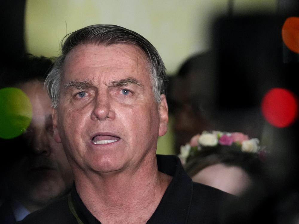 Former President Jair Bolsonaro speaks to the press after being formally charged by the federal police with attempted coup, at the airport in Brasilia, Brazil on Monday.