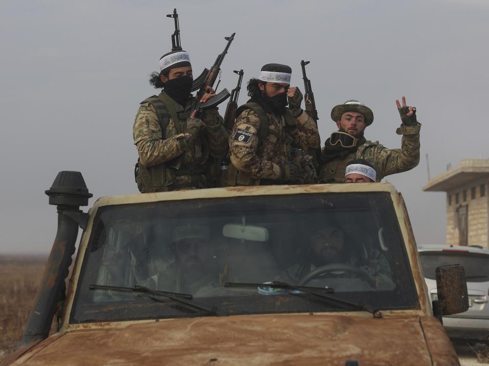 Syrian opposition fighters ride in a truck in Talhiya, Idlib countryside, Syria, on Friday.