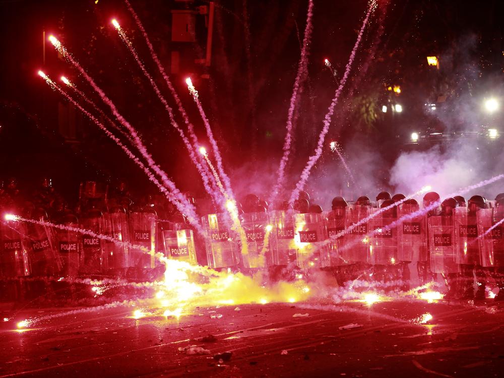Demonstrators use firecrackers against police during a rally against the government's decision to suspend negotiations on joining the European Union for four years, outside the parliament's building in Tbilisi, Georgia, early Sunday, Dec. 1, 2024.