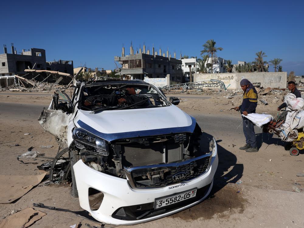 People check a car hit by an Israeli strike in Khan Yunis in the southern Gaza Strip on Saturday. Five people were reported killed, including three World Central Kitchen workers, Gaza's health ministry said.