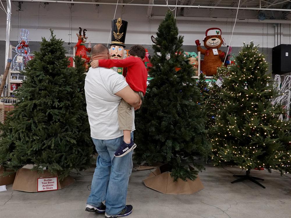 A man and child look at artificial Christmas trees on display at a Home Depot in Miami in 2021.