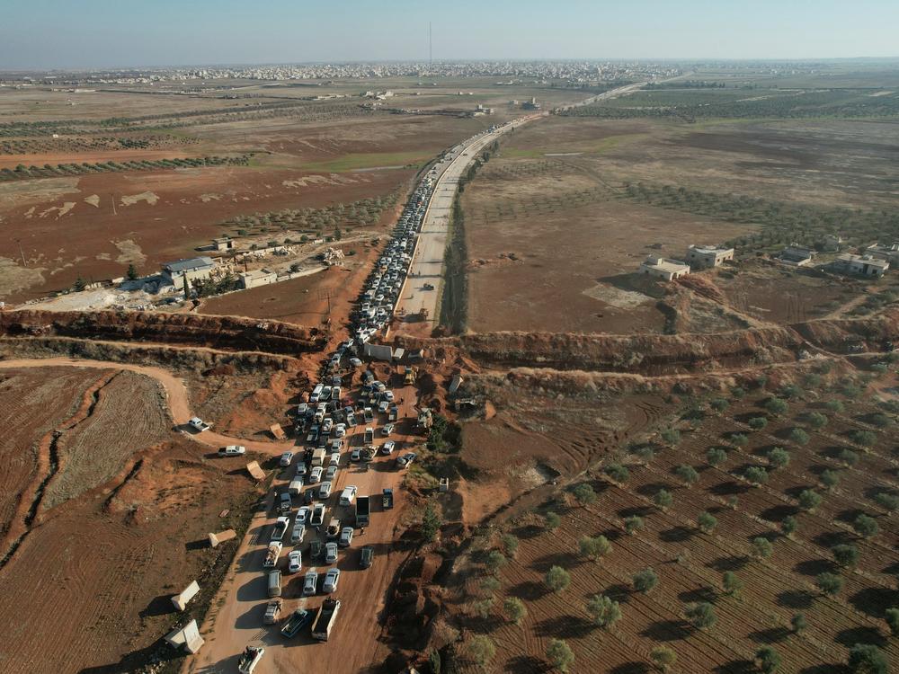 An aerial view shows people crossing an antigovernment checkpoint as they return to Saraqib in the eastern part of Idlib province in northwestern Syria on Dec. 1.