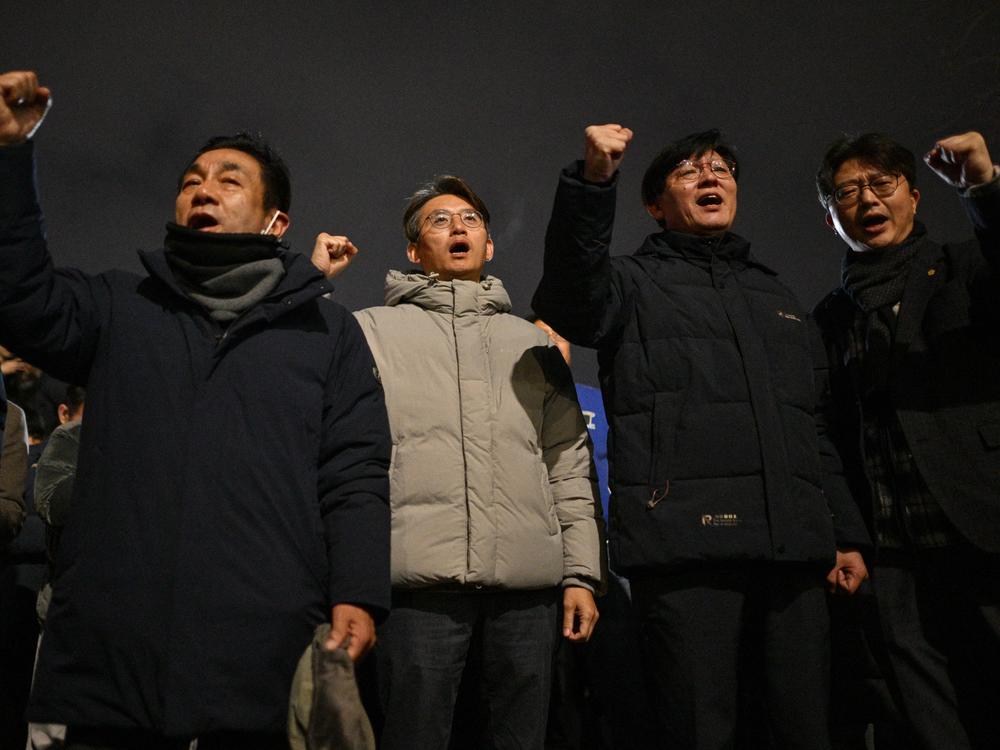 People gesture as they gather outside the National Assembly in Seoul on December 4, 2024, after President Yoon Suk Yeol declared emergency martial law.