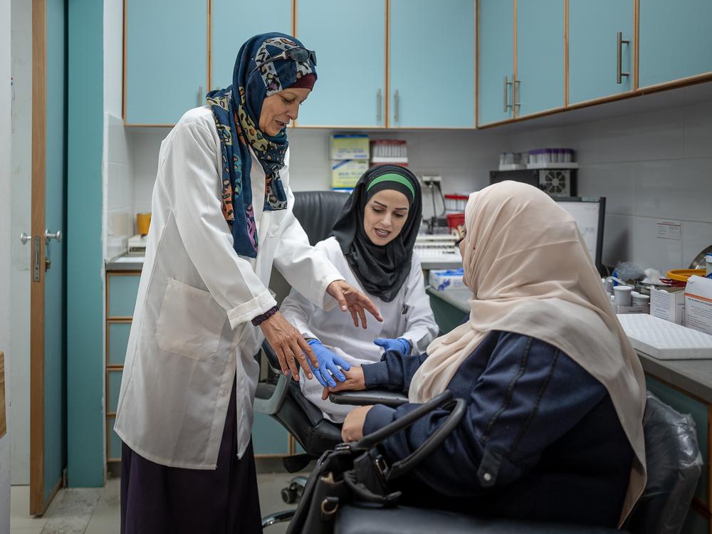 Dr. Majida Nasr (left) treats a patient at the UNRWA clinic in Qalandia on Nov. 14.