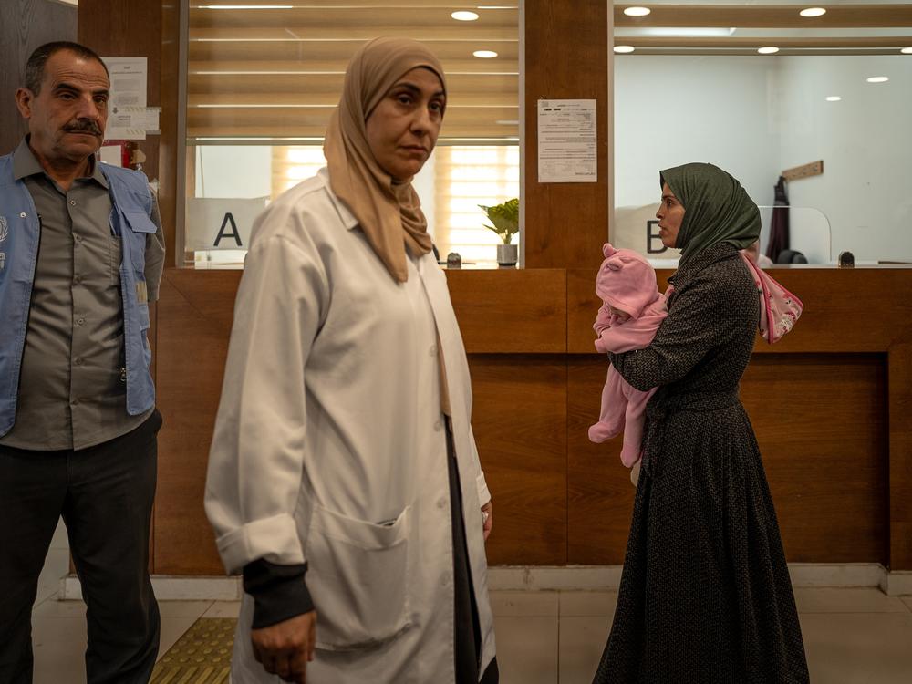 Hiam Hawarin holds her baby in an UNRWA clinic in Qalandia on Nov. 14.