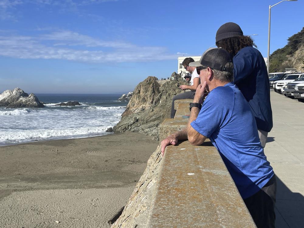 People watch the waves come in at Ocean Beach in San Francisco after an earthquake was felt widely across Northern California on Thursday.