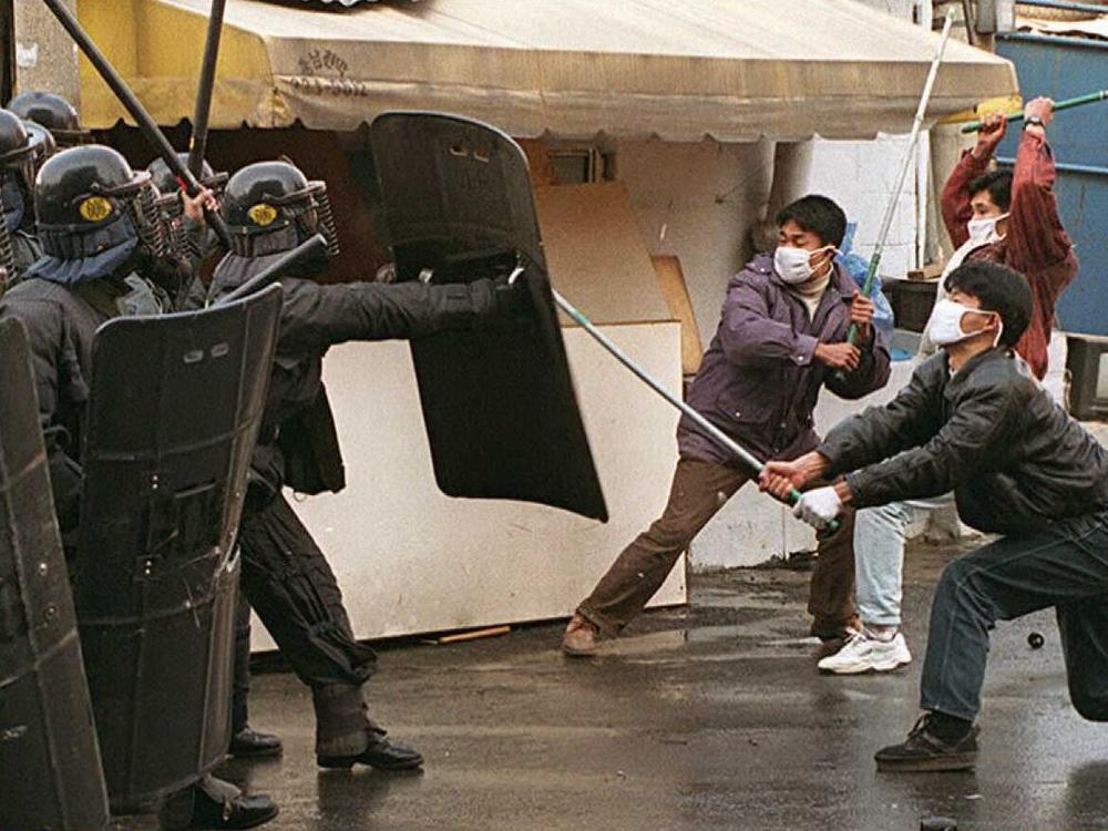 The events of 1980 left scars on South Korean society. Above, riot police beat back student demonstrators wielding iron bars who rushed out of side alleys in November 1995 to try to attack the home of former president Chun Doo-hwan, whom the students accused of ordering the 1980 Kwangju massacre.