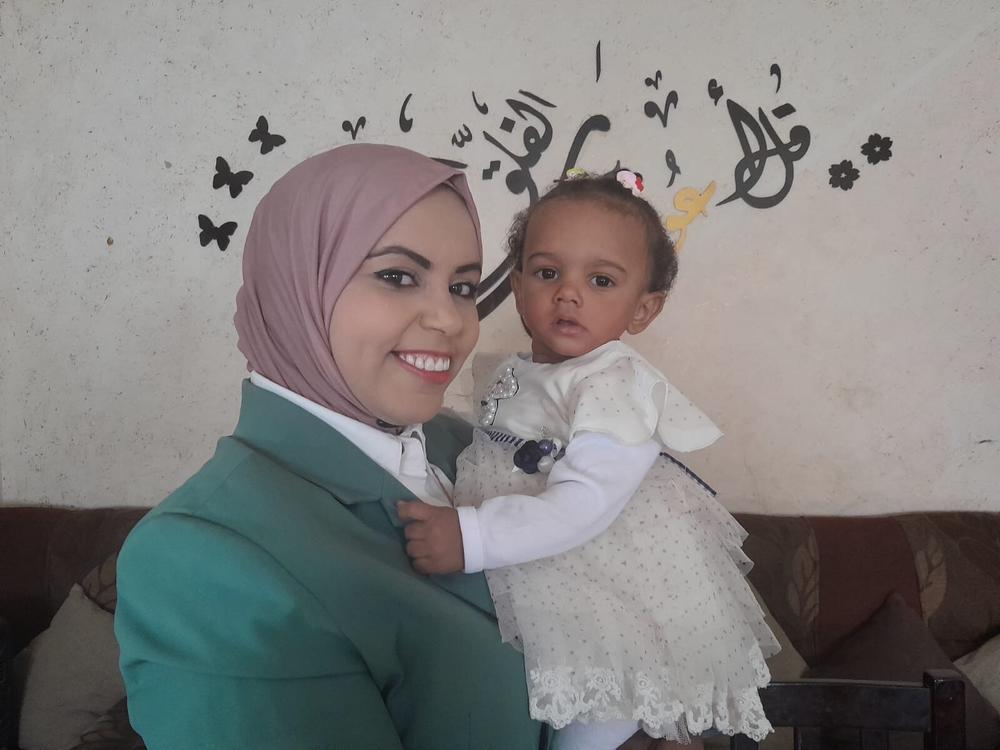 Amal Abu Khatleh, a nurse at a Gaza hospital that admitted an unidentified infant last November, took the baby in and gave her the name Malak, meaning angel. Abu Khatleh holds Malak on her first birthday in October, in Deir al-Balah, Gaza Strip.