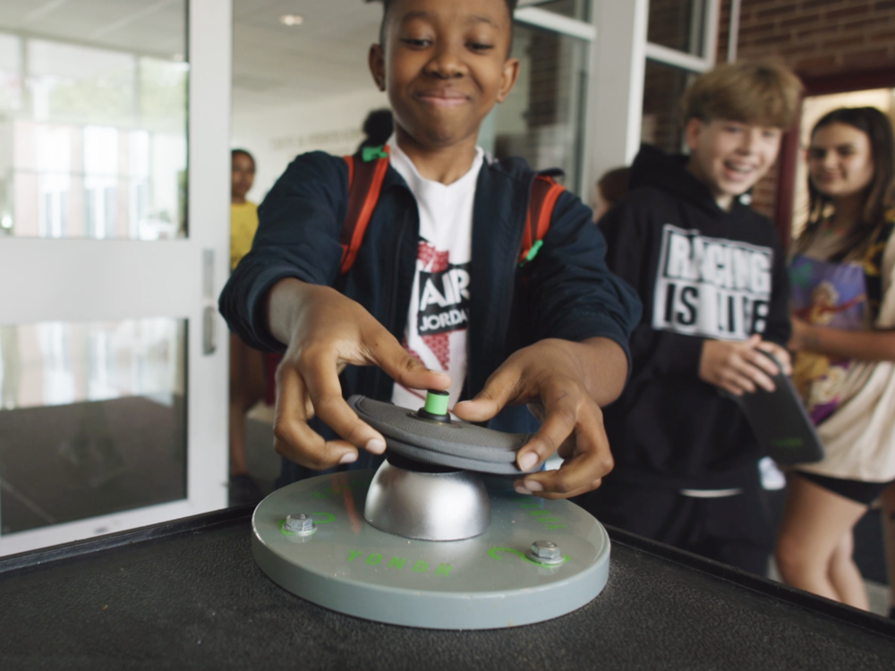Students use a special magnet to unlock pouches at an 