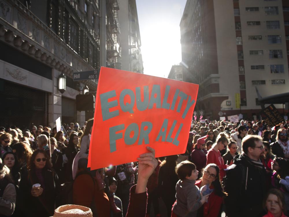 Kelly Crowder (center) holds up a sign as thousands of protesters gather for the Women's March against President Donald Trump Jan. 21, 2017, in Los Angeles.