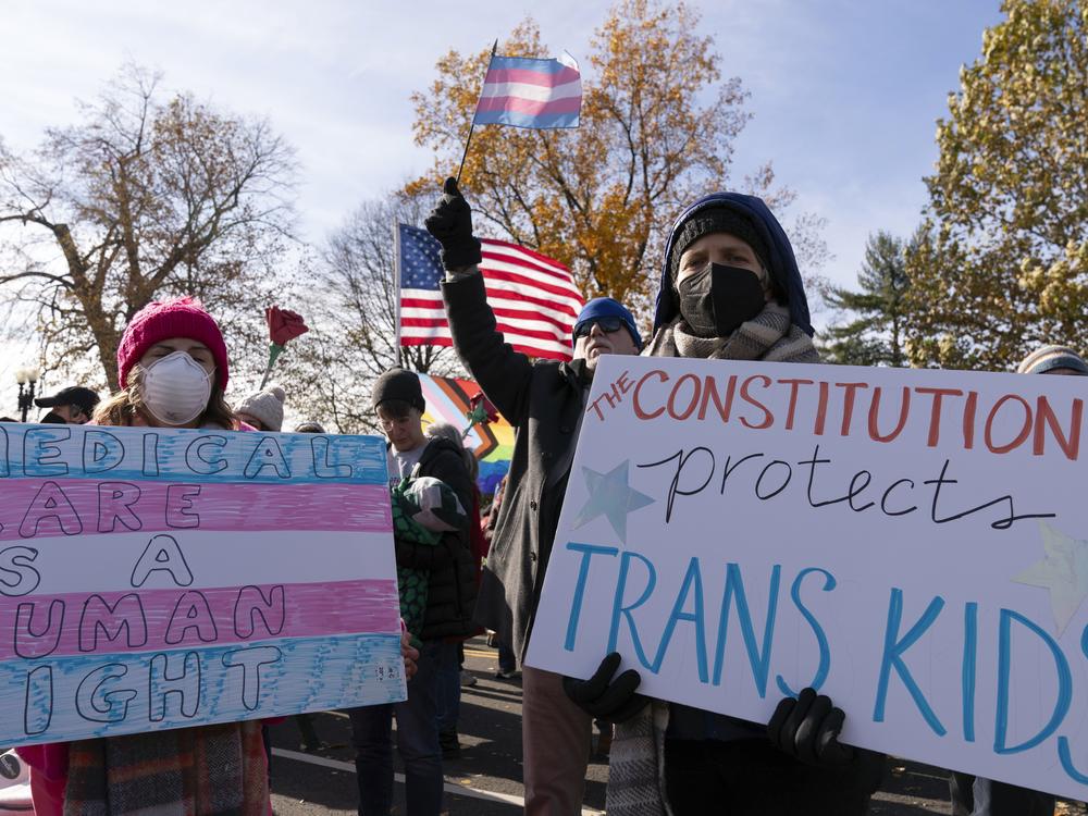 Supporters of transgender rights hold signs as they rally outside the Supreme Court on Wednesday in Washington, D.C., as arguments begin in a case regarding a Tennessee law banning gender-affirming medical care for transgender youth.