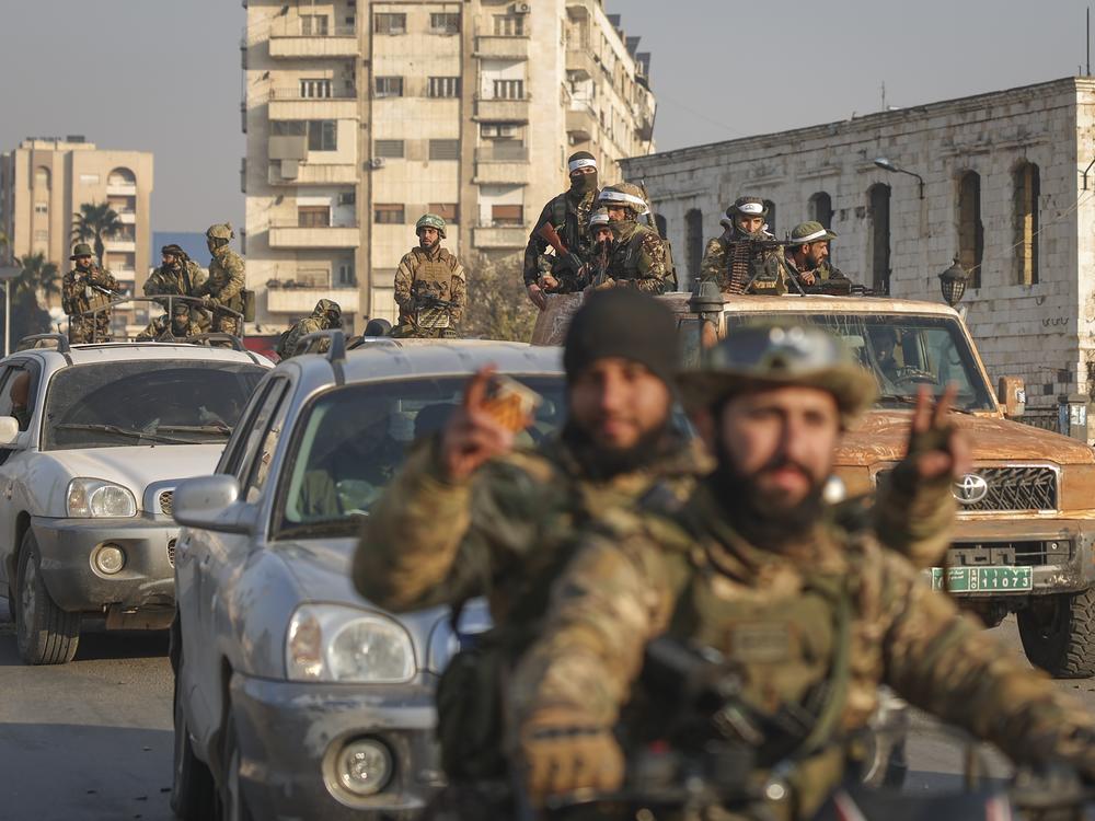 Syrian opposition fighters ride along the streets in the aftermath of the opposition's takeover of Hama, Syria, Friday, Dec. 6, 2024.