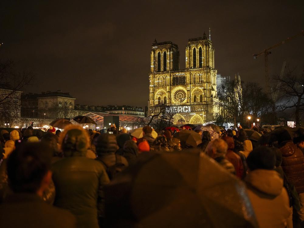 Spectators gather outside France's iconic Notre Dame Cathedral on Saturday in Paris for its formal reopening.
