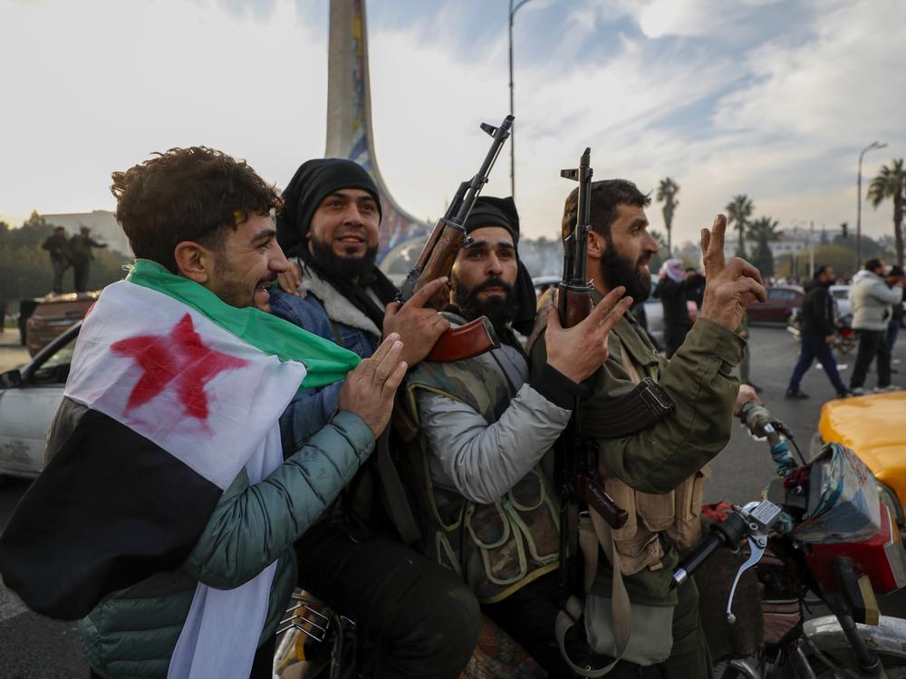 Syrian opposition fighters celebrate after the Syrian government collapsed in Damascus, Syria, Sunday, Dec. 8, 2024.