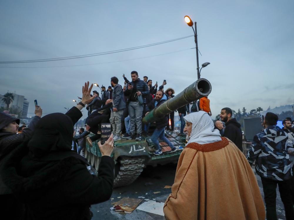 Syrians celebrate the arrival of opposition fighters in Damascus, Syria, Sunday Dec. 8, 2024.